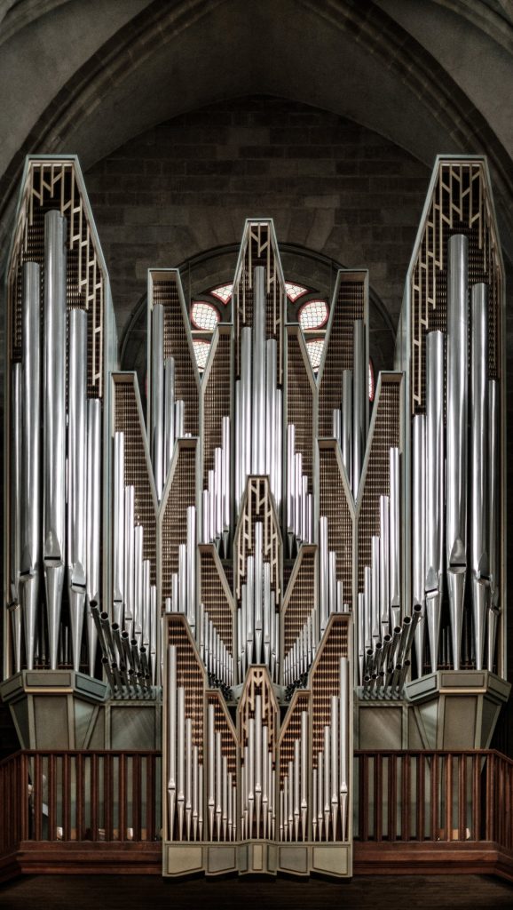 The pipes of a church organ rising into the roof